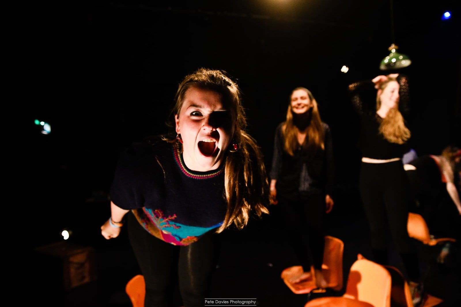 On stage mid-performance, lit by Thomas Edwards