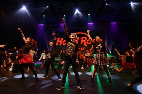 We Will Rock You — rock-concert lighting state over the band and cast